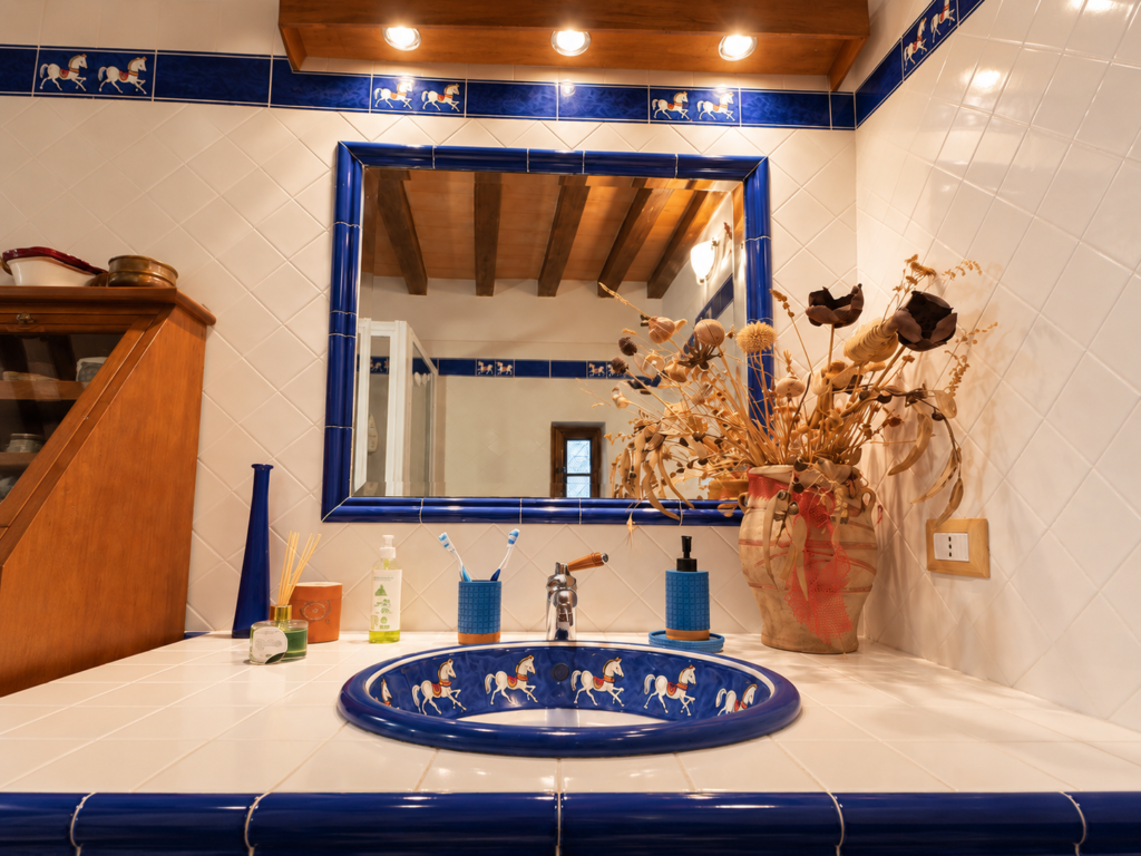 Bathroom with blue ceramic basin and traditional tiles at Vicolo di Sorano holiday home