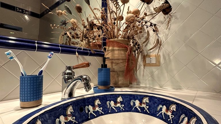 Handcrafted blue ceramic washbasin with horse motif at Vicolo di Sorano