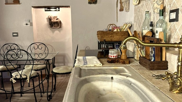 Rustic Tuscan kitchen with exposed wooden beams at Vicolo di Sorano