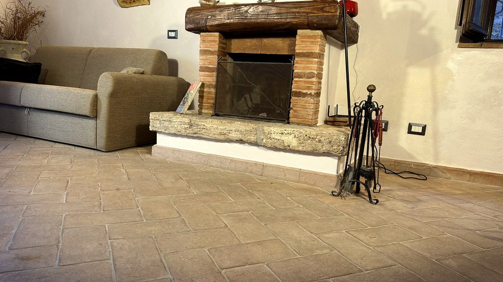 Traditional fireplace and living room with terracotta floor at Vicolo di Sorano