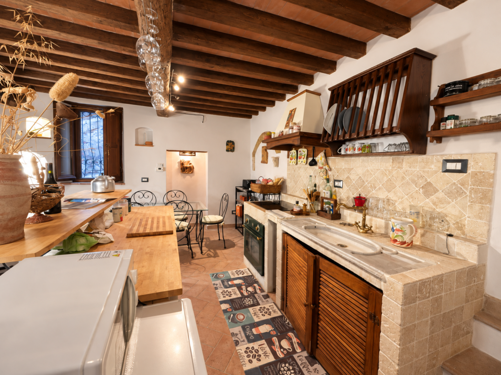 Traditional kitchen with wooden beams at Vicolo di Sorano holiday home in Tuscany